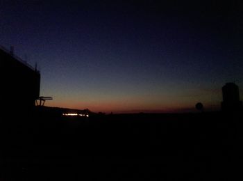 Silhouette landscape against clear sky at night