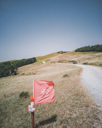 Red flag on field against clear sky