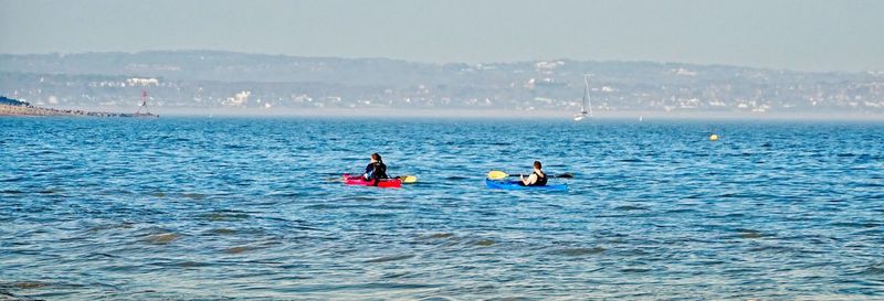 People on sea against sky