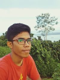 Portrait of young man against sky