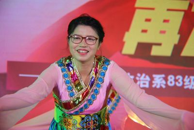 Smiling woman in traditional clothing standing on stage