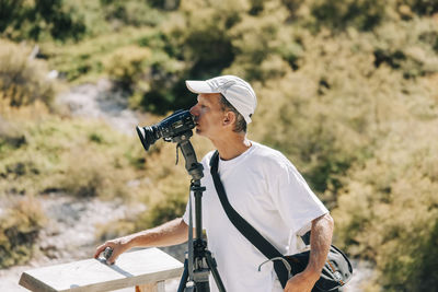 Man photographing with camera while standing outdoors