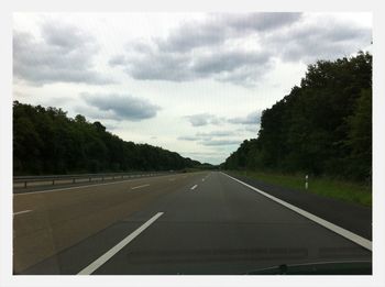 Empty road against cloudy sky