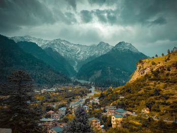 Scenic view of townscape and mountains against sky