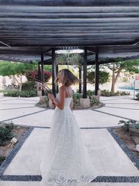 Rear view of woman standing against wall
