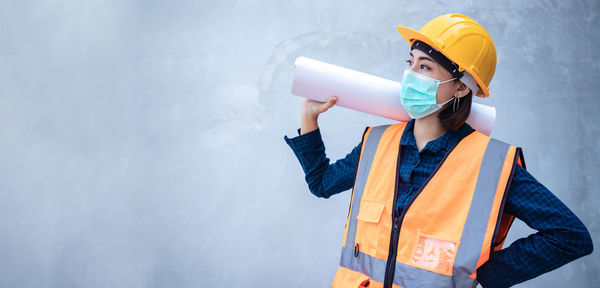 Young woman working on wall