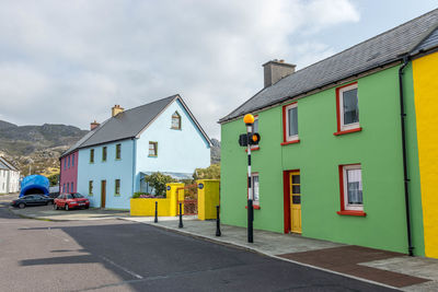 Houses by street against sky in city