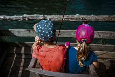 Siblings fishing and waiting on a sunny day