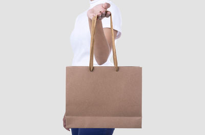 Midsection of man holding paper against white background