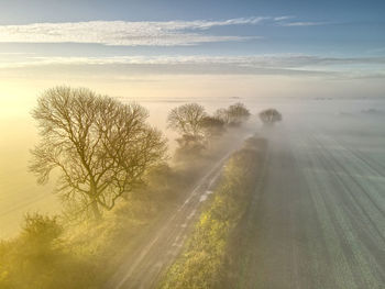 Scenic view of landscape against sky during foggy weather