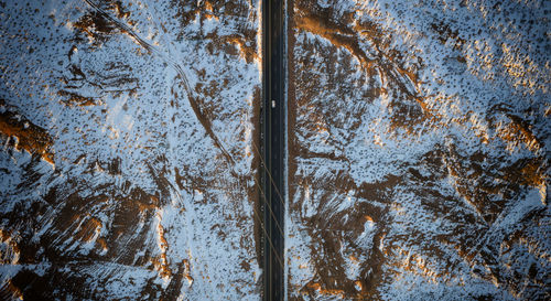 Aerial view of road amidst snow covered land during winter