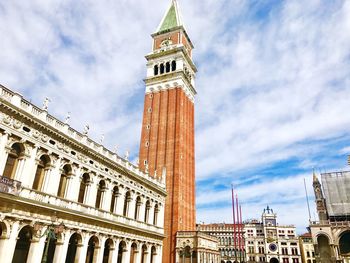 Low angle view of clock tower amidst buildings in city