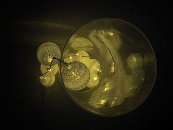 Close-up of illuminated light bulb against black background