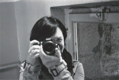 Close-up of young woman holding camera