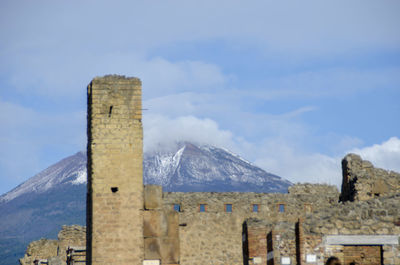 Castle on mountain against sky during winter