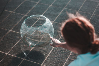 Close-up of woman holding glass container at fountain