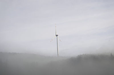 Wind turbines on land against sky