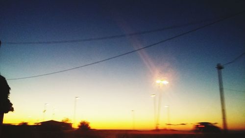 Silhouette road against clear sky during sunset