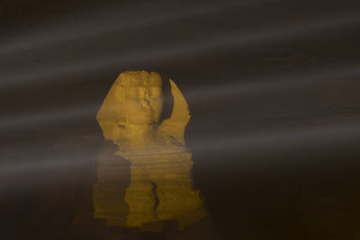 Sphinx of giza in the night illuminated by laser rays