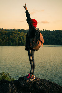 Full length of girl standing at lake against sky