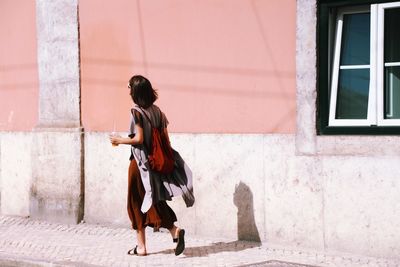 Full length of woman walking on footpath