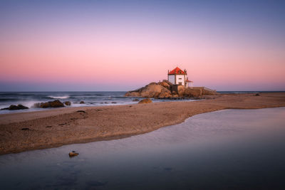 Scenic view of beach against sky during sunset