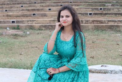 Portrait of a young woman sitting outdoors