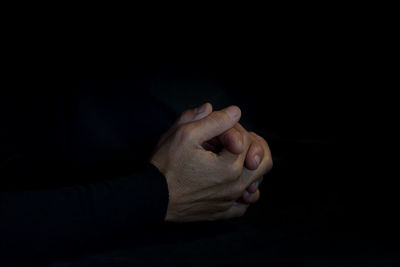 Close-up of person hand against black background