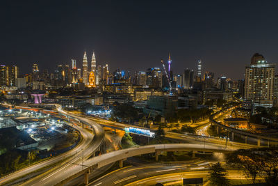 High angle view of illuminated street amidst buildings at night