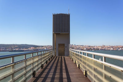 View of bridge and buildings against clear blue sky