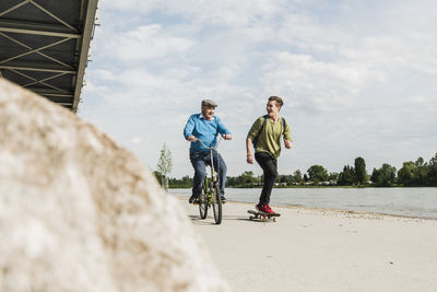 Grandfather and grandson having fun together at riverside