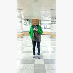 Full length rear view of man standing on tiled floor