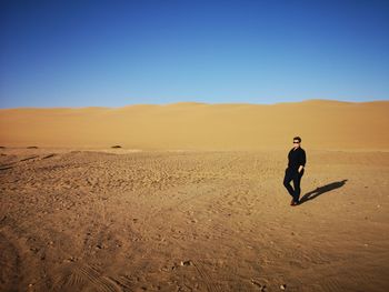 Full length of man on desert against clear sky