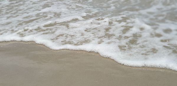 High angle view of waves rushing towards shore