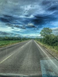 Road by trees against sky