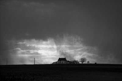 Panoramic view of field against cloudy sky