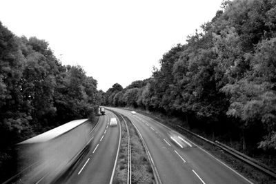 Road amidst trees against clear sky