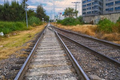 Railroad tracks by trees against sky