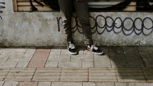 Low section of person standing on footpath