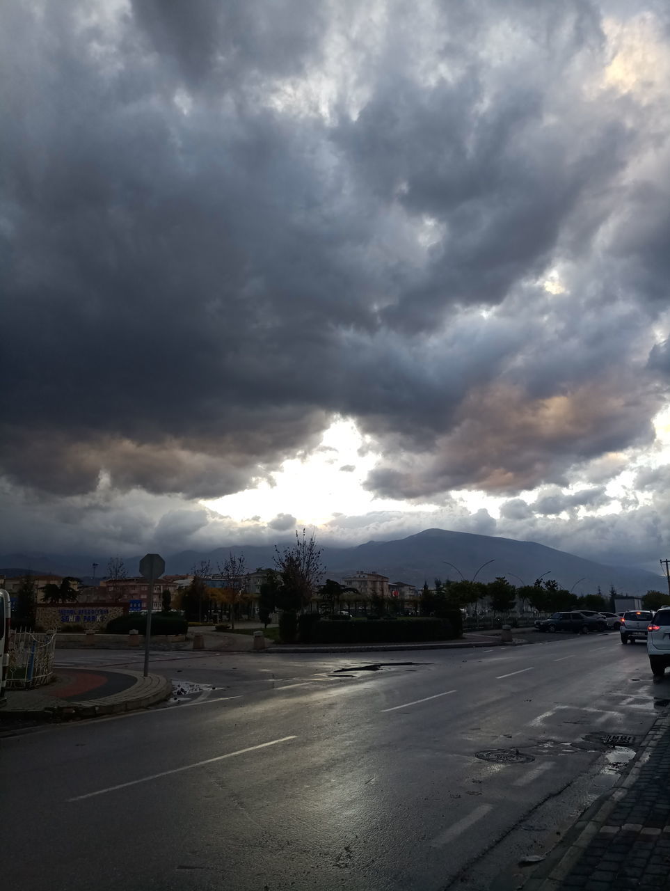 ROAD IN CITY AGAINST CLOUDY SKY