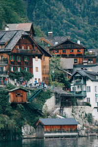 Houses by river against mountain in city