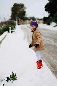 Boy walking on snow covered tree