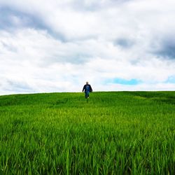 Scenic view of grassy field against cloudy sky