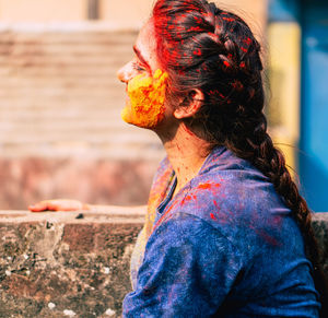 Side view of young woman with powder paint on face during holi