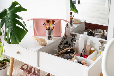 Stylish room interior with elegant dressing table and monstera plants