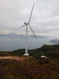 Windmill on field against sky