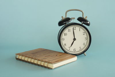 Close-up of alarm clock against blue background