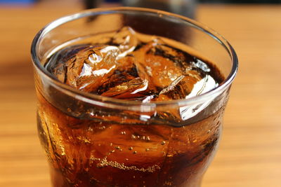 Close-up of ice cubes in cola on table