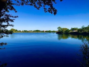 Scenic view of lake against clear blue sky