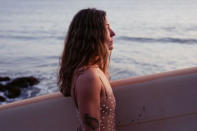 Beautiful, fit woman with surfboard on beach in tofino